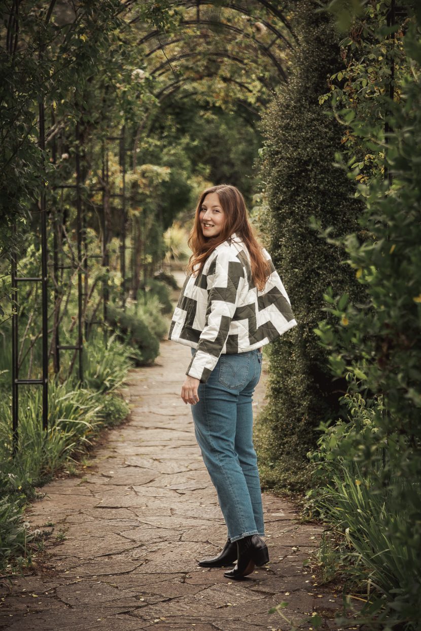 Coudre une veste en patchwork matelassée femme qui porte une veste en patchwork bicolore minimaliste dans la verdure