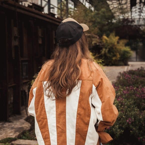 femme debout portant une surchemise ocre et blanc cassé avec le dos patchwork